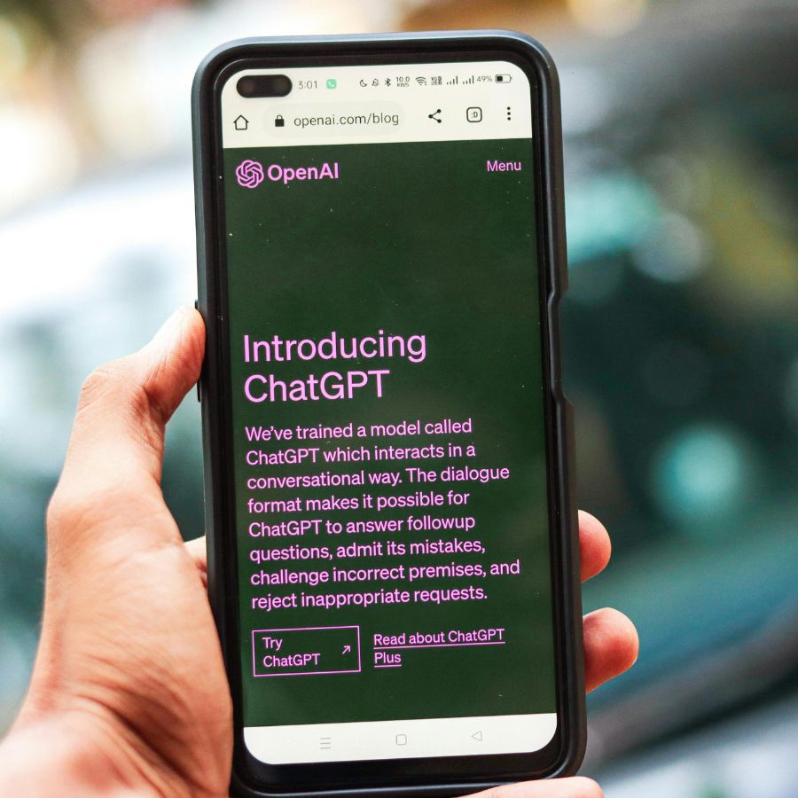 Smartphone mit geöffneter Webseite von OpenAI, auf der ChatGPT vorgestellt wird.