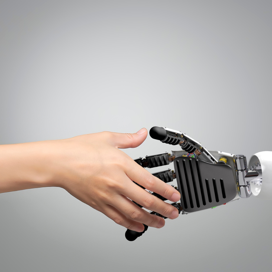Menschliche Hand greift nach einer Roboterhand – symbolisiert Zusammenarbeit zwischen Mensch und künstlicher Intelligenz.