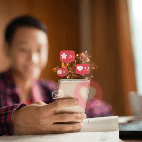 Person hält ein Smartphone, darüber schweben Social-Media-Benachrichtigungen mit Likes, Kommentaren und Favoriten – symbolisiert Reichweite, Engagement und digitale Interaktion im Social-Media-Marketing.