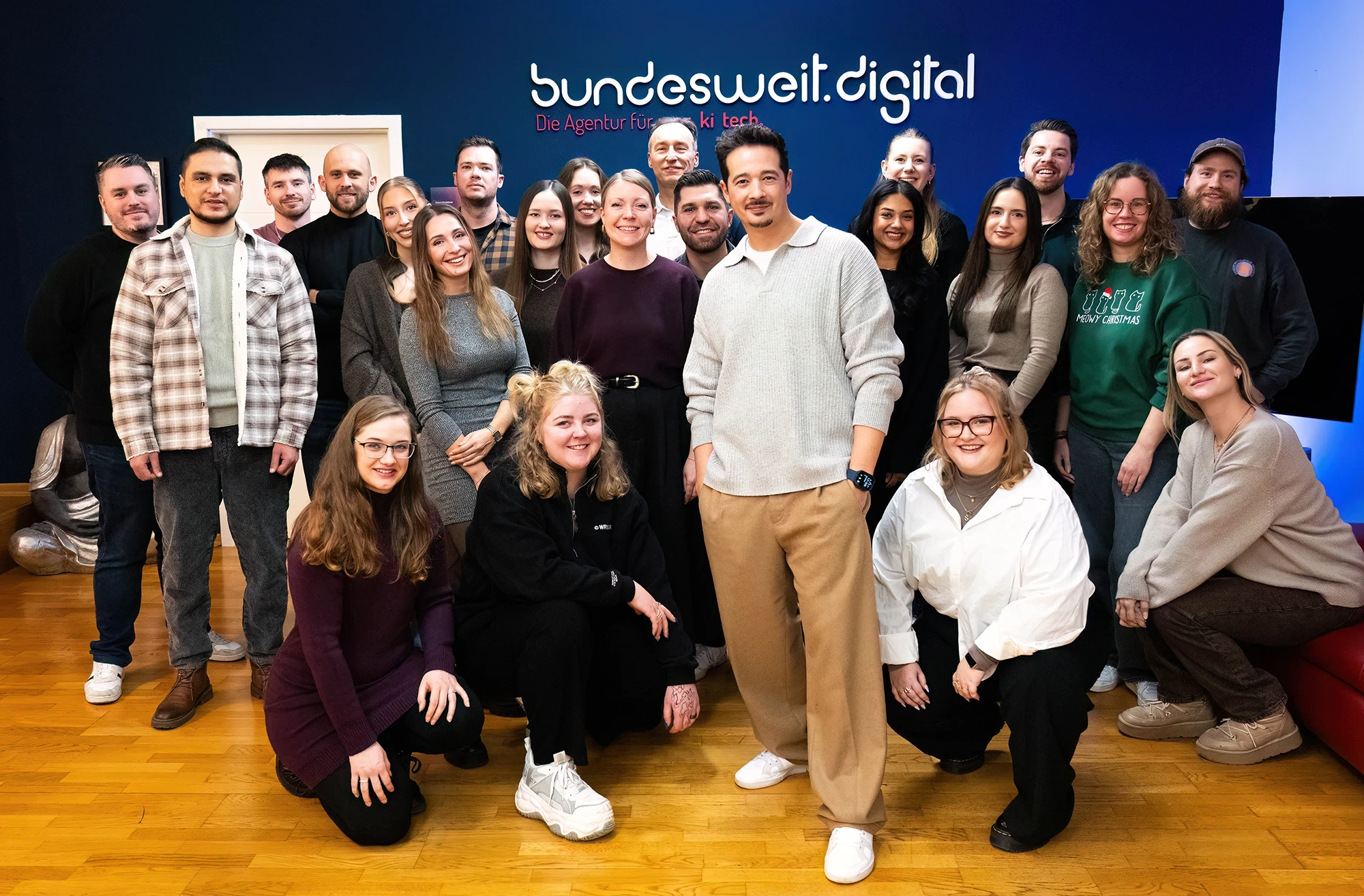 Team der KI-Agentur bundesweit.digital in Hannover vor dem markitech-Logo
